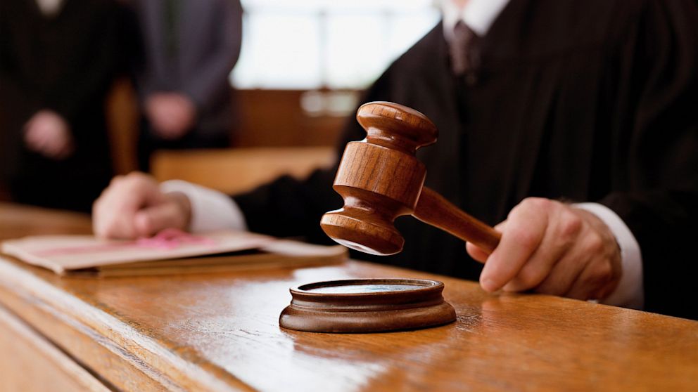 Close up of a judge's hand with gavel.