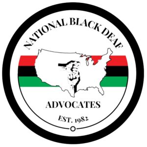 A logo for the National Black Deaf Advocates, featuring a central design with the outline of the United States in white against a black background, superimposed with an ASL sign for "I love you" highlighted in red. Below the map, there's a stripe with the Pan-African colors: red, black, and green. The logo is encircled by the text "National Black Deaf Advocates" at the top and "EST. 1982" at the bottom, both in black on a white background, symbolizing the organization’s long-standing commitment to advocacy within the Black Deaf community.