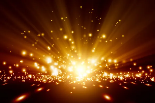 A vivid display of bright, golden lights exploding from a central point, spreading outwards with intense radiance against a dark background, resembling a firework display or a cosmic burst.